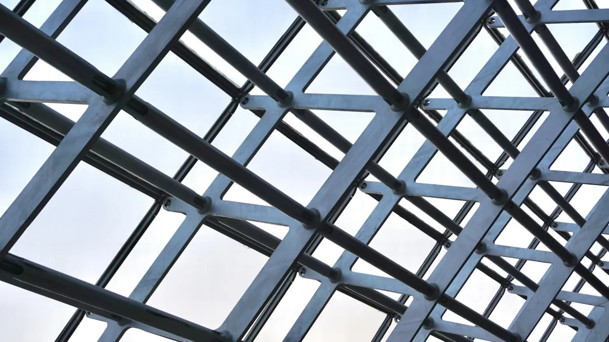 Grid of grey steel roof members seen from below