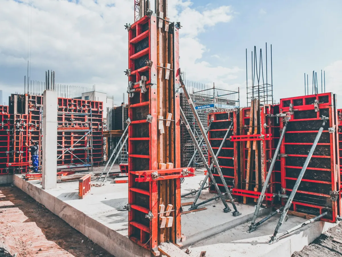 Concrete columns cast in red steel formwork on a building site