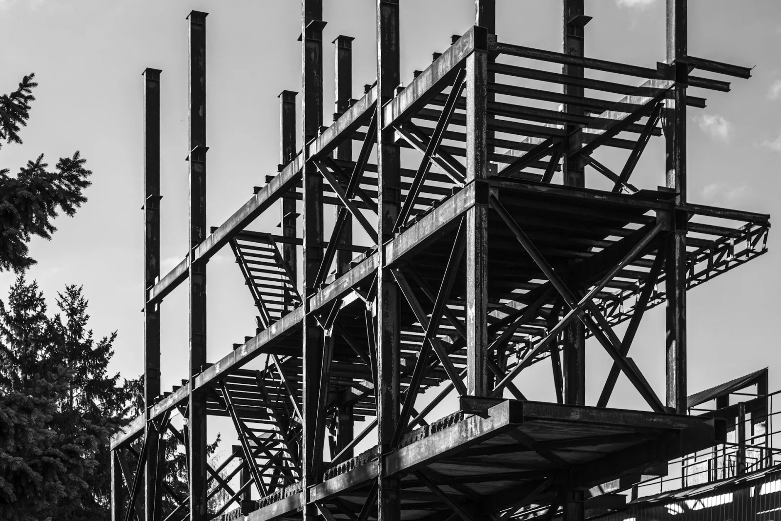 Black-and-white photo of a multi-storey steel frame under construction